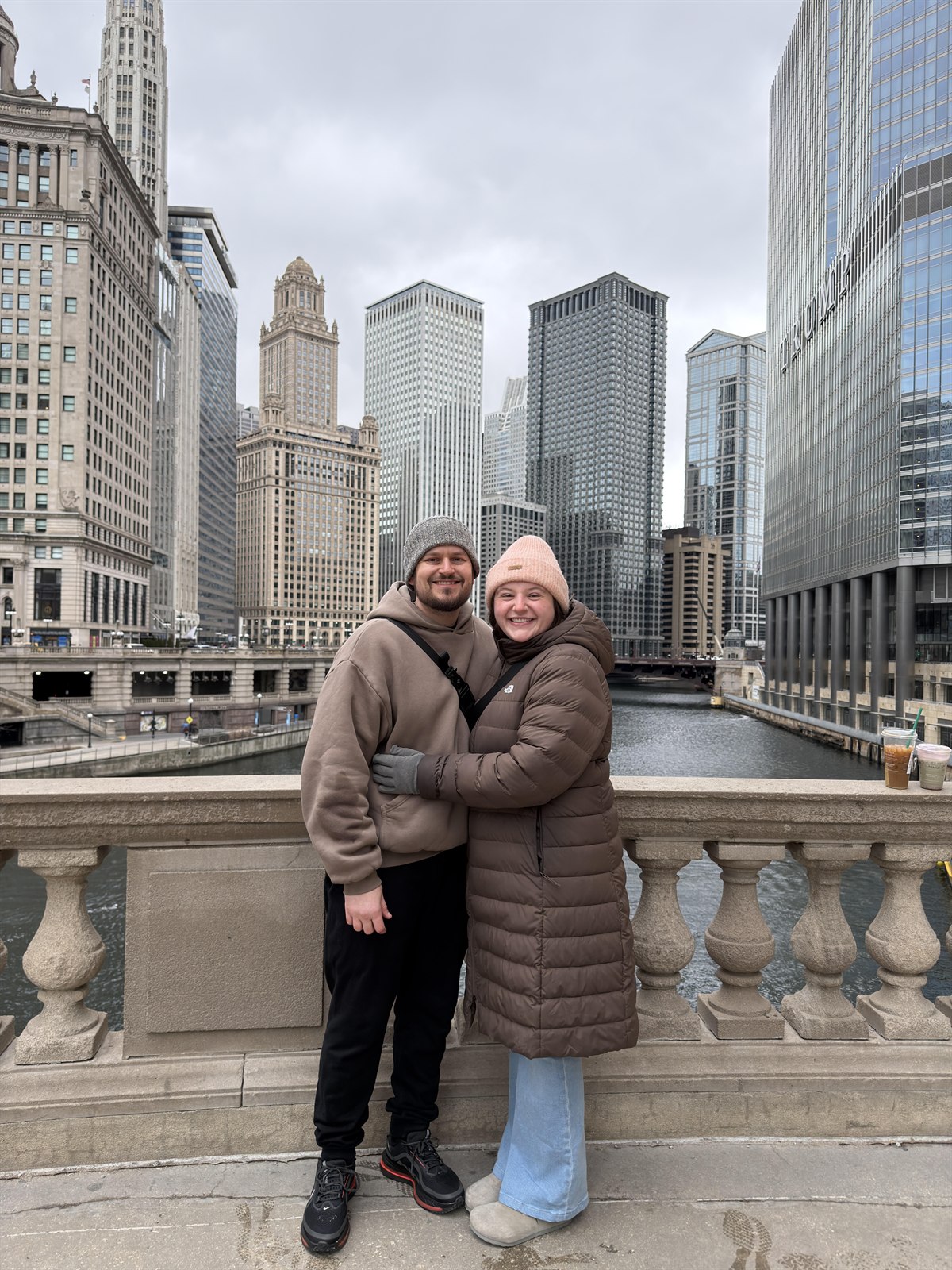 Cody and his partner on a bridge over the Chicago River in winter, the Wrigley Building behind them