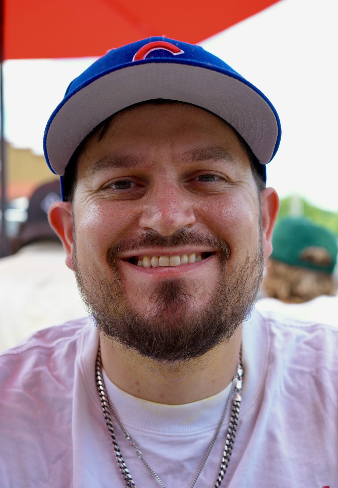 Cody Heart in a Cubs cap, close, on a bright afternoon